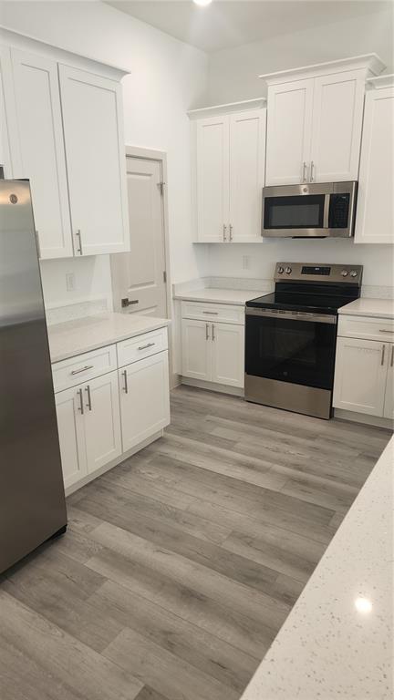 23469 Roscoe Avenue Punta Gorda, FL 33980 - Photo 3 of 26 a kitchen with granite countertop white cabinets and black appliances