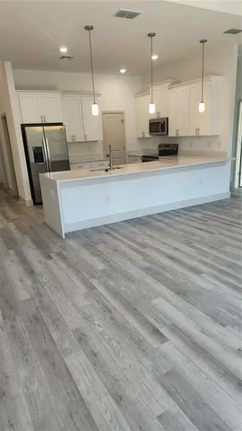 a large room with kitchen island lots of wooden furniture