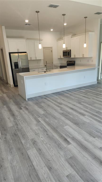 23469 Roscoe Avenue Punta Gorda, FL 33980 - Photo 5 of 26 a large room with kitchen island lots of wooden furniture