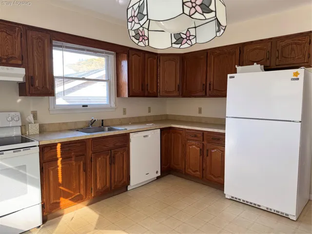 a kitchen with a refrigerator sink and cabinets