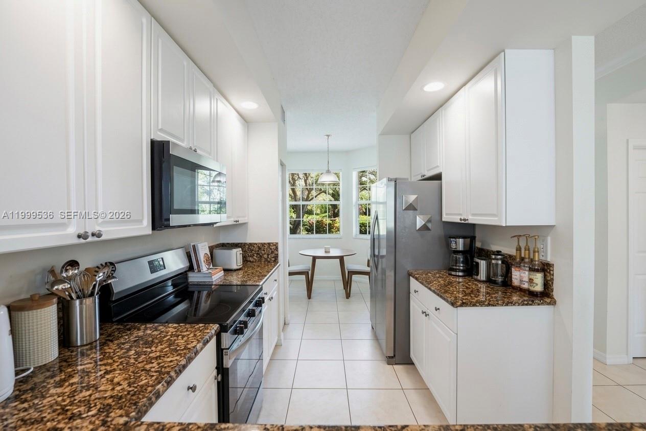 26 Royal Palm Way, Unit 304 Boca Raton, FL 33432 - Photo 3 of 38 a kitchen with granite countertop a refrigerator stove top oven and sink