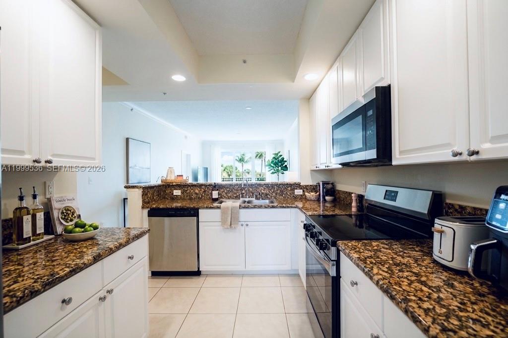 26 Royal Palm Way, Unit 304 Boca Raton, FL 33432 - Photo 10 of 38 a kitchen with stainless steel appliances granite countertop a stove top oven a sink a counter space and cabinets