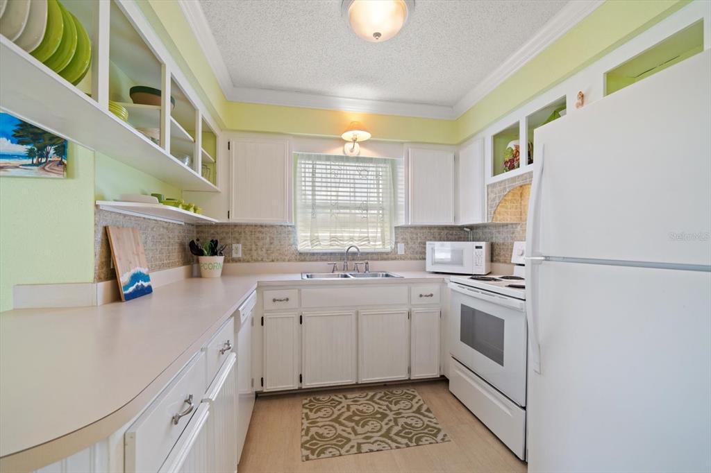 800 East Gulf Boulevard, Unit 5 Indian Rocks Beach, FL 33785 - Photo 13 of 52 a kitchen with a sink cabinets and window