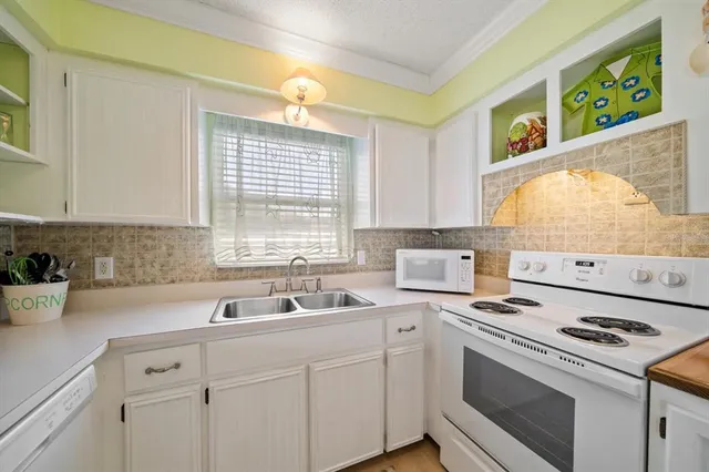 a white refrigerator freezer and a stove sitting inside of a kitchen