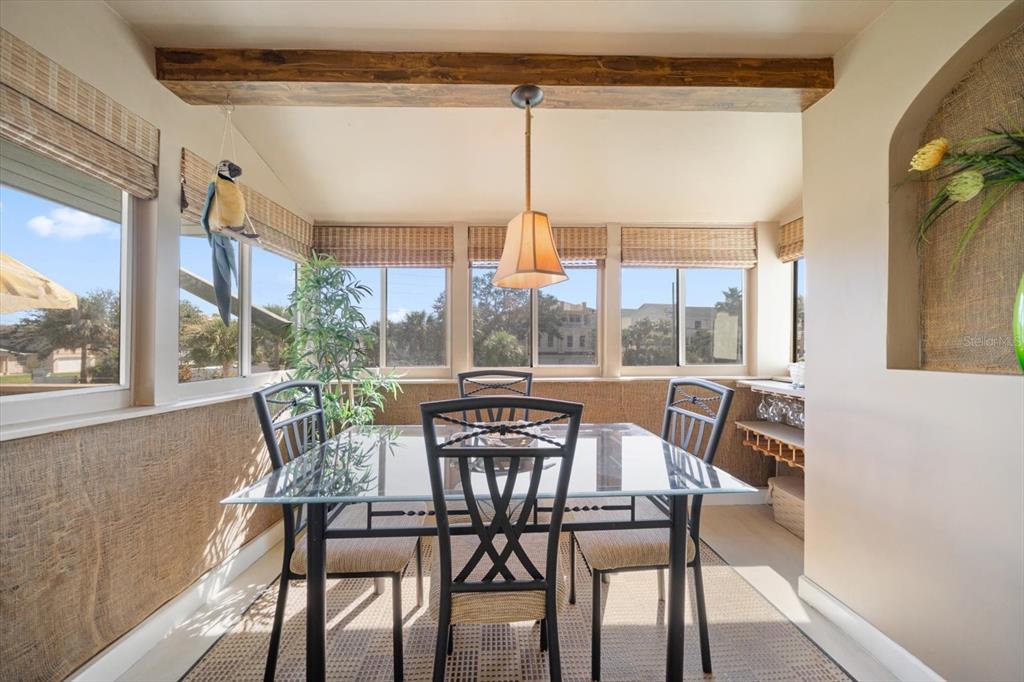 800 East Gulf Boulevard, Unit 5 Indian Rocks Beach, FL 33785 - Photo 19 of 52 a dining room with furniture a chandelier and wooden floor