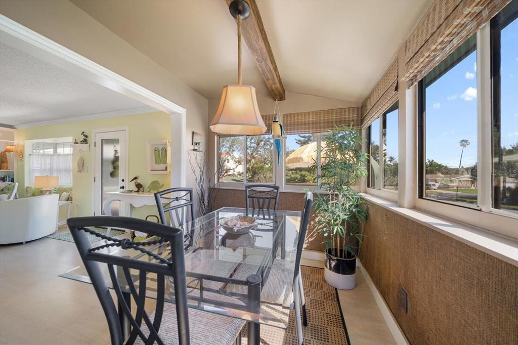 800 East Gulf Boulevard, Unit 5 Indian Rocks Beach, FL 33785 - Photo 21 of 52 a view of a dining room with furniture wooden floor and a chandelier