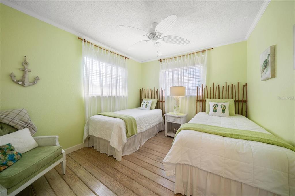 800 East Gulf Boulevard, Unit 5 Indian Rocks Beach, FL 33785 - Photo 28 of 52 a spacious bedroom with two beds and a chandelier