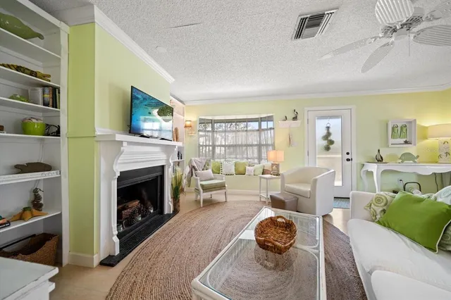 a living room with furniture a fireplace and a floor to ceiling window