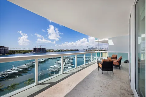 a view of a balcony with couch and chairs