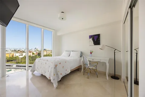 a bed room with a bed and a large window