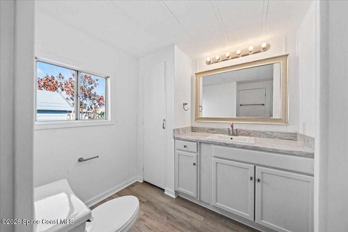 1848 Seagrape Street Northeast Palm Bay, FL 32905 - Photo 12 of 27 a bathroom with a toilet a sink and mirror