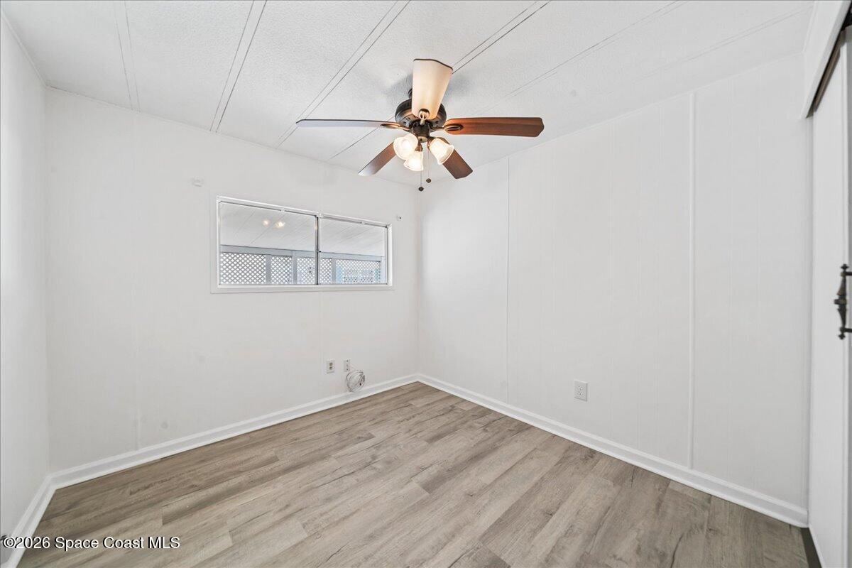 1848 Seagrape Street Northeast Palm Bay, FL 32905 - Photo 15 of 27 an empty room with wooden floor ceiling fan and window