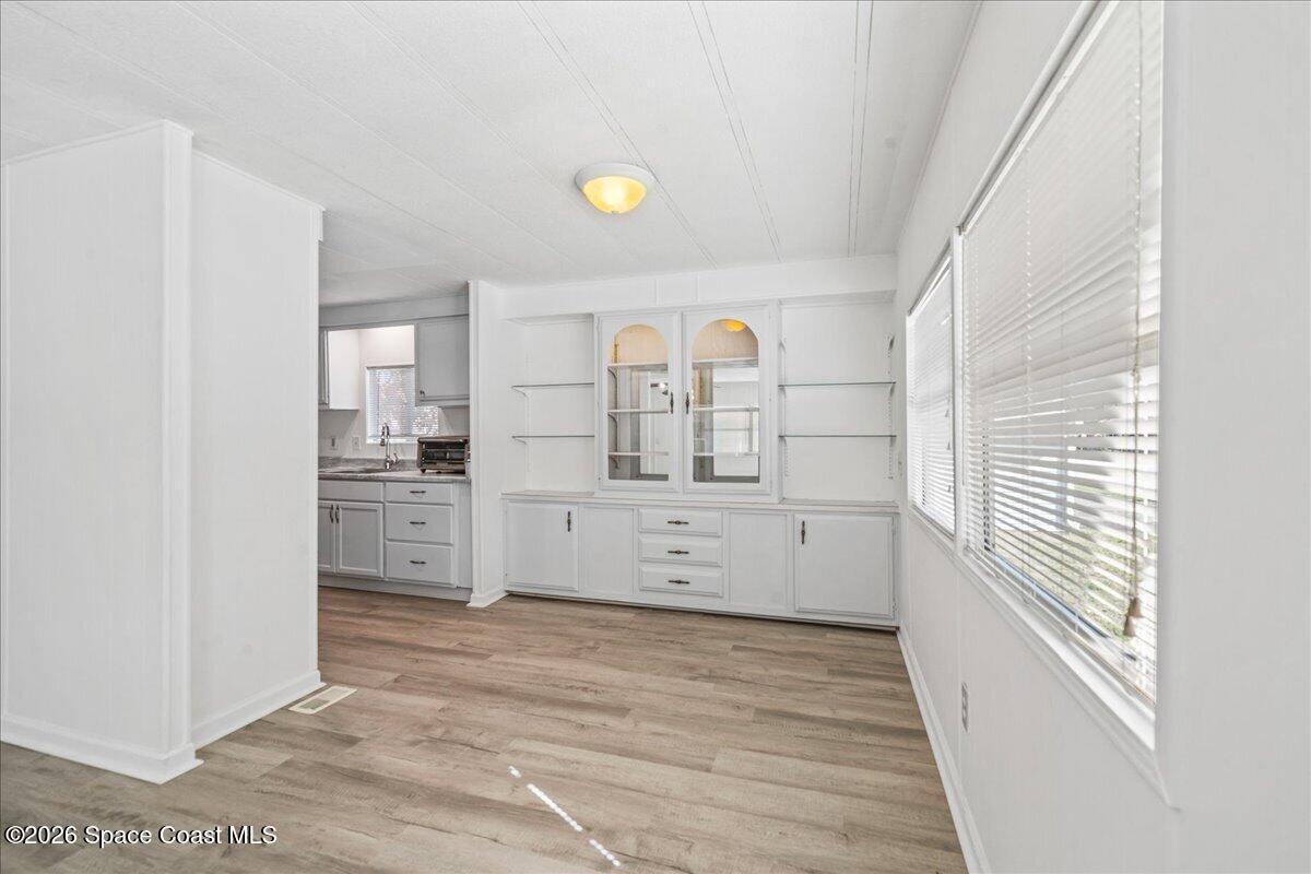 1848 Seagrape Street Northeast Palm Bay, FL 32905 - Photo 5 of 27 a view of a kitchen with white cabinets and wooden floor