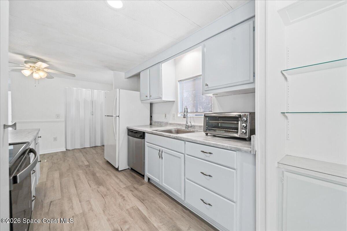 1848 Seagrape Street Northeast Palm Bay, FL 32905 - Photo 6 of 27 a kitchen with a refrigerator a stove a microwave and cabinets