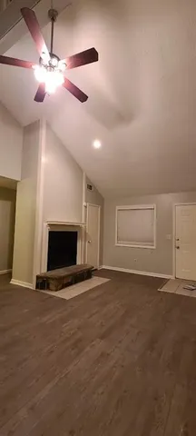 a view of empty room with a fireplace and fan