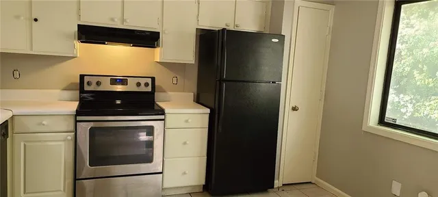 a kitchen with a refrigerator and a stove