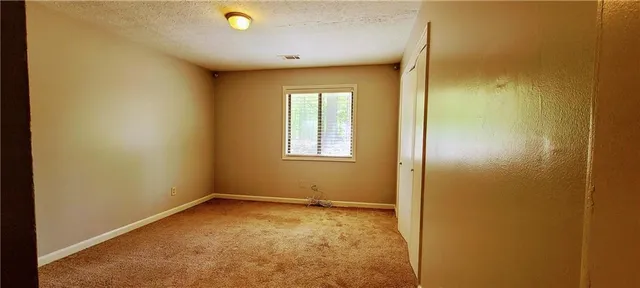 an empty room with windows and closet