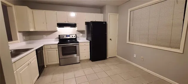 a kitchen with a stove top oven and cabinets