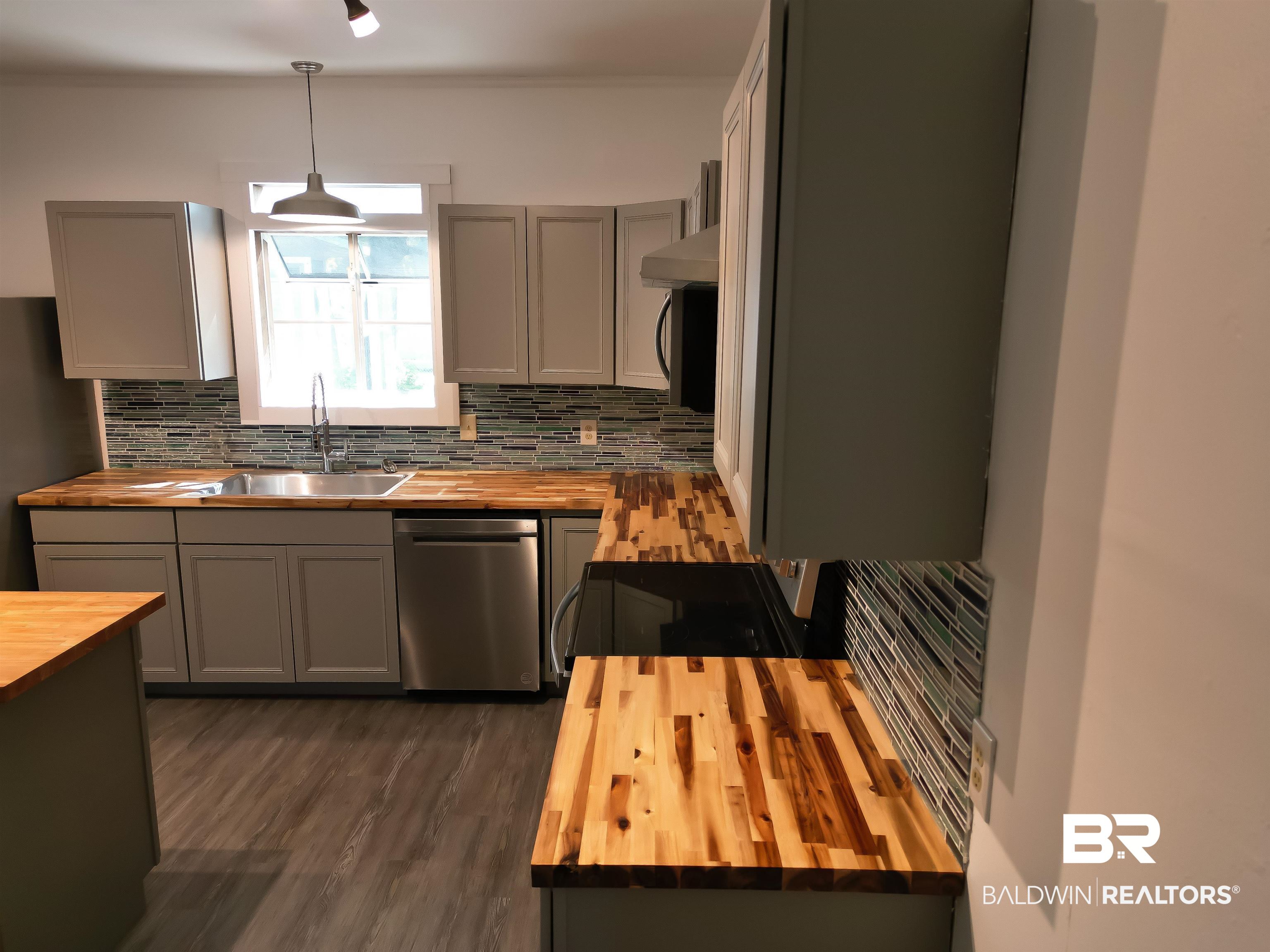 73 Liberty Street Monroeville, AL 36460 - Photo 5 of 29 Kitchen with sink, butcher block counters, hanging light fixtures, and tasteful backsplash