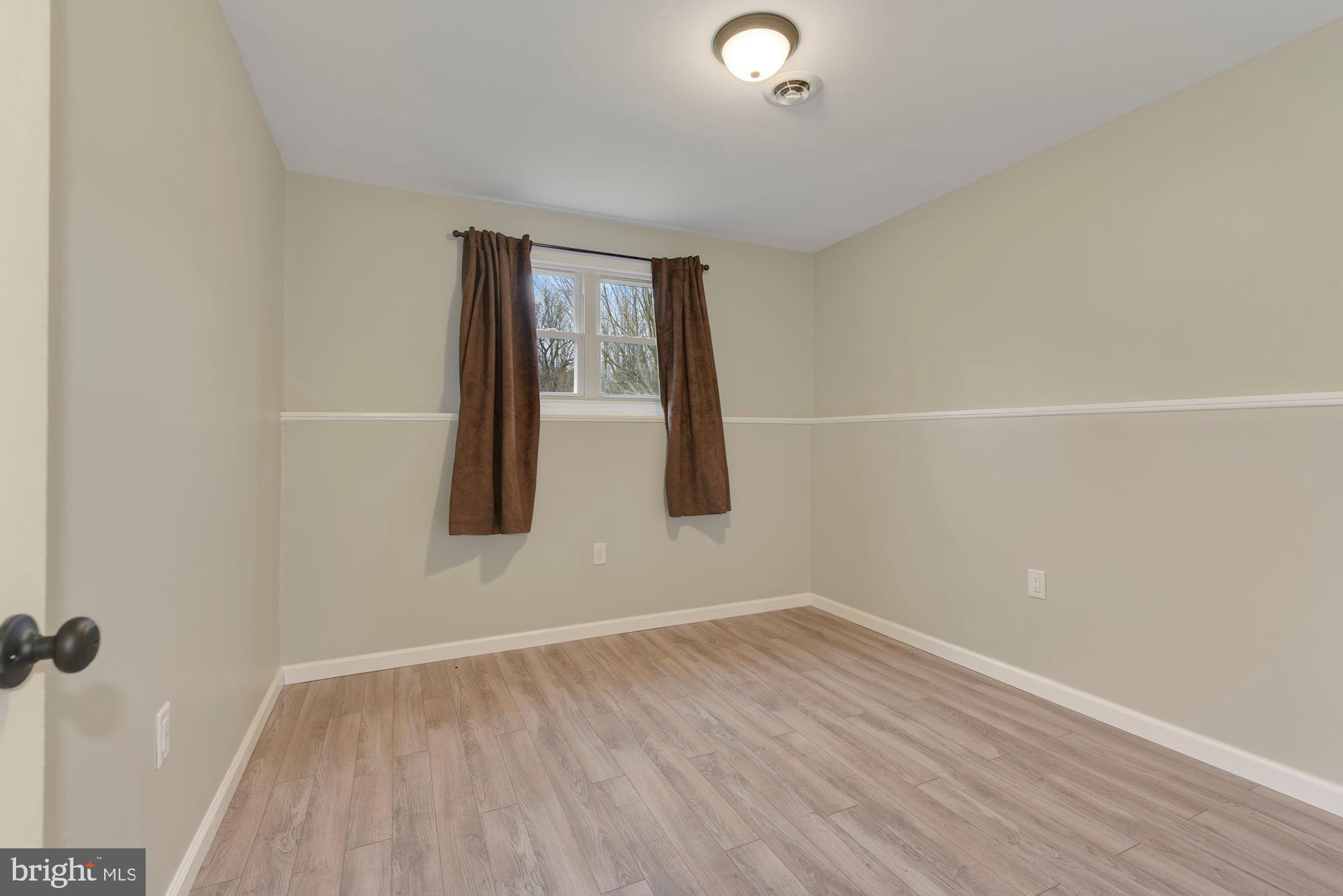 221 Arneys Mt Road Pemberton, NJ 08068 - Photo 17 of 28 an empty room with wooden floor and windows
