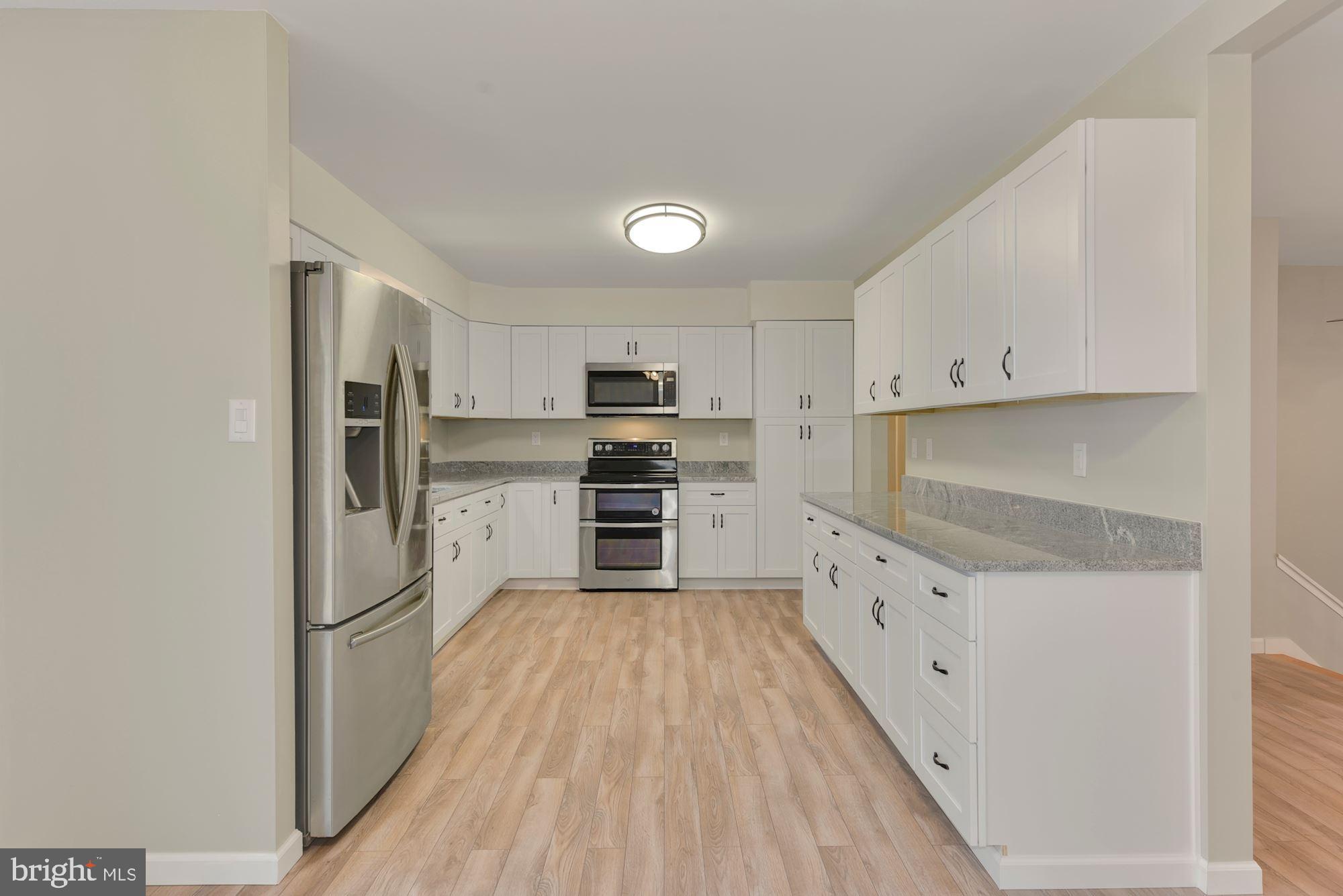 221 Arneys Mt Road Pemberton, NJ 08068 - Photo 8 of 28 a kitchen with granite countertop a refrigerator oven a sink dishwasher and white cabinets with wooden floor