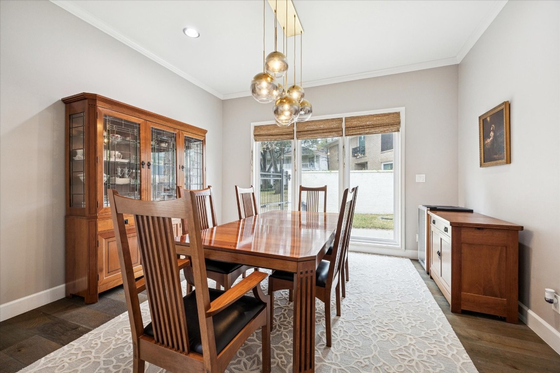 242 Vanderpool Lane Houston, TX 77024 - Photo 12 of 45 The formal dining room features a modern light fixture and a large window with a view of the sideyard, providing ample natural light. Dining room measures 14x13.