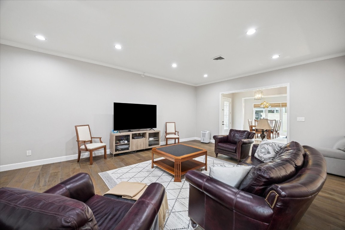 242 Vanderpool Lane Houston, TX 77024 - Photo 18 of 45 This spacious living room well-lit with recessed lighting and opens to the dining and family room areas, providing a welcoming and functional space for relaxation and entertainment.