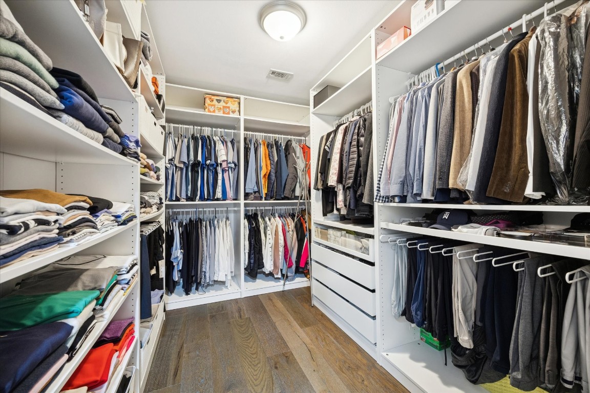 242 Vanderpool Lane Houston, TX 77024 - Photo 26 of 45 This spacious walk-in closet features organized shelving and hanging space for clothing, shoes, and accessories. It offers ample storage with a clean, modern design and efficient lighting.