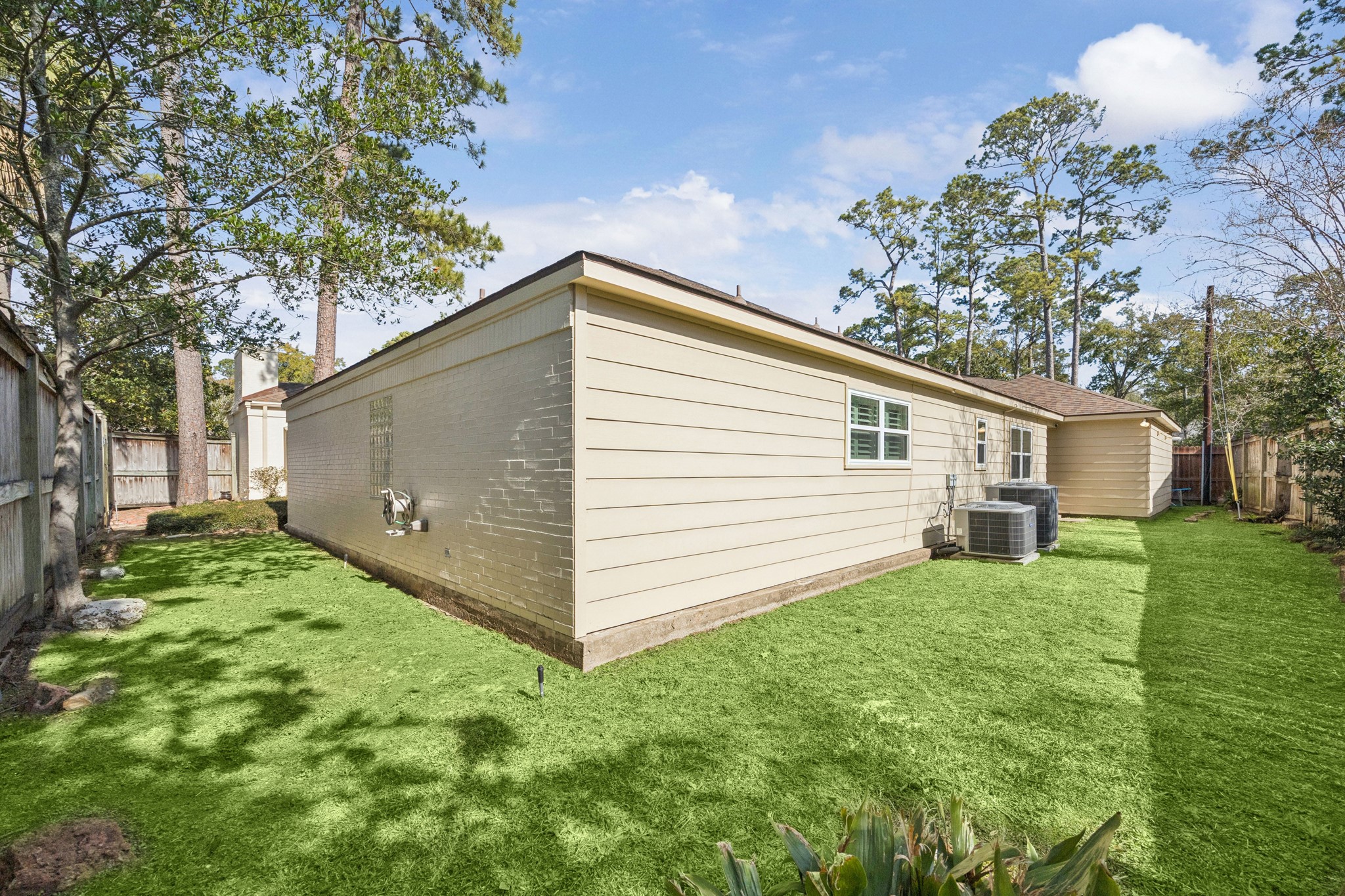 242 Vanderpool Lane Houston, TX 77024 - Photo 29 of 41 A well-maintained backyard with a neat lawn, bordered by a wooden fence, and featuring a side access to the patio area.