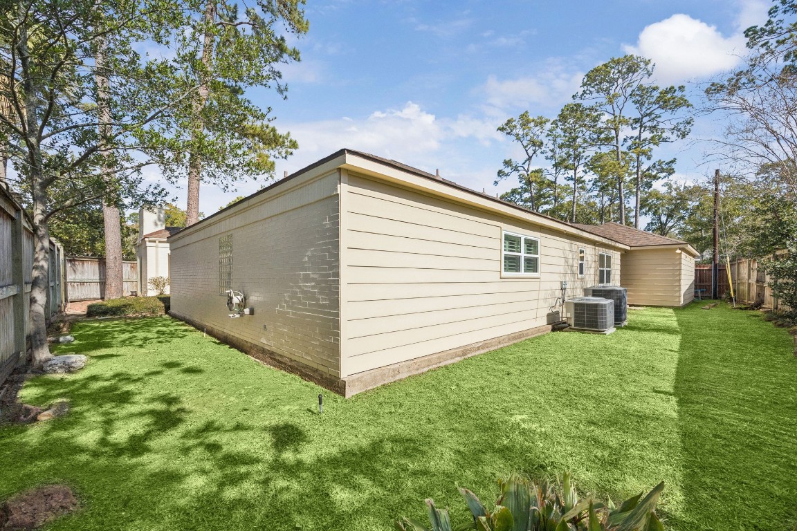 242 Vanderpool Lane Houston, TX 77024 - Photo 33 of 45 A well-maintained backyard with a neat lawn, bordered by a wooden fence, and featuring a side access to the patio area.