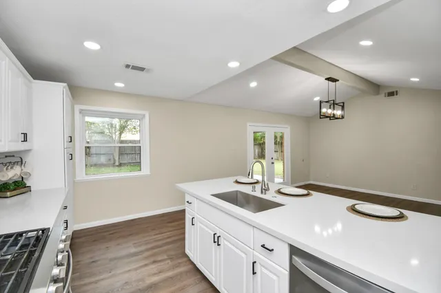a kitchen with a sink and wooden floor