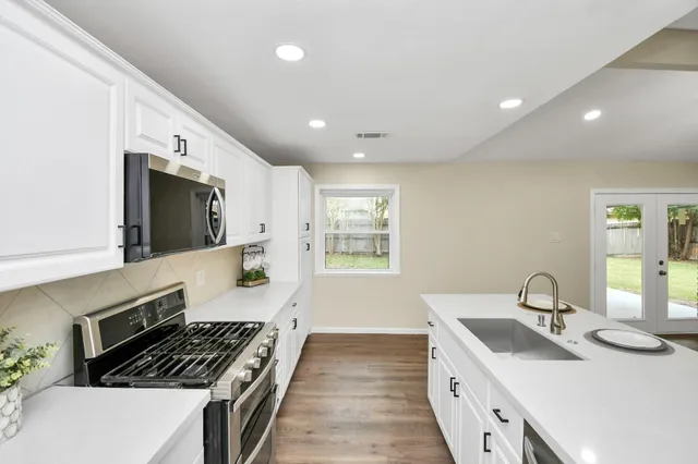 a kitchen with sink stove and cabinets