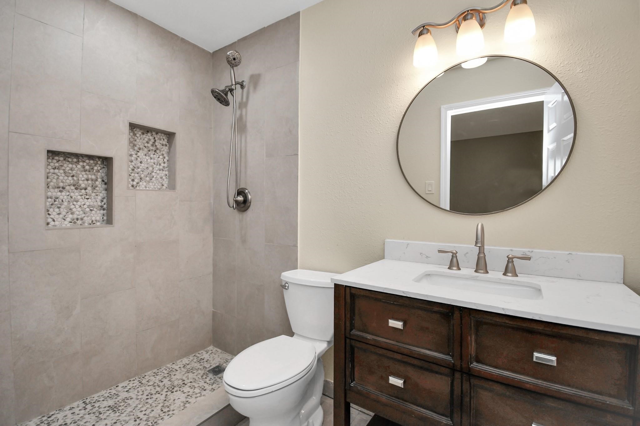 531 Edgebrook Drive Houston, TX 77034 - Photo 16 of 26 a bathroom with a toilet a sink a mirror and vanity