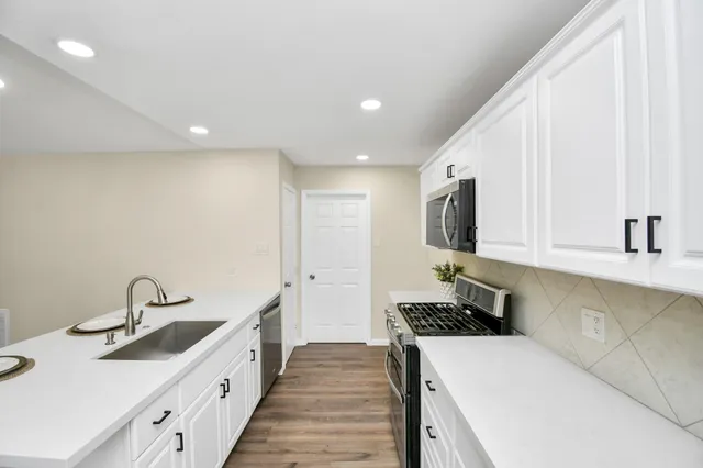 a kitchen with sink a stove and cabinets