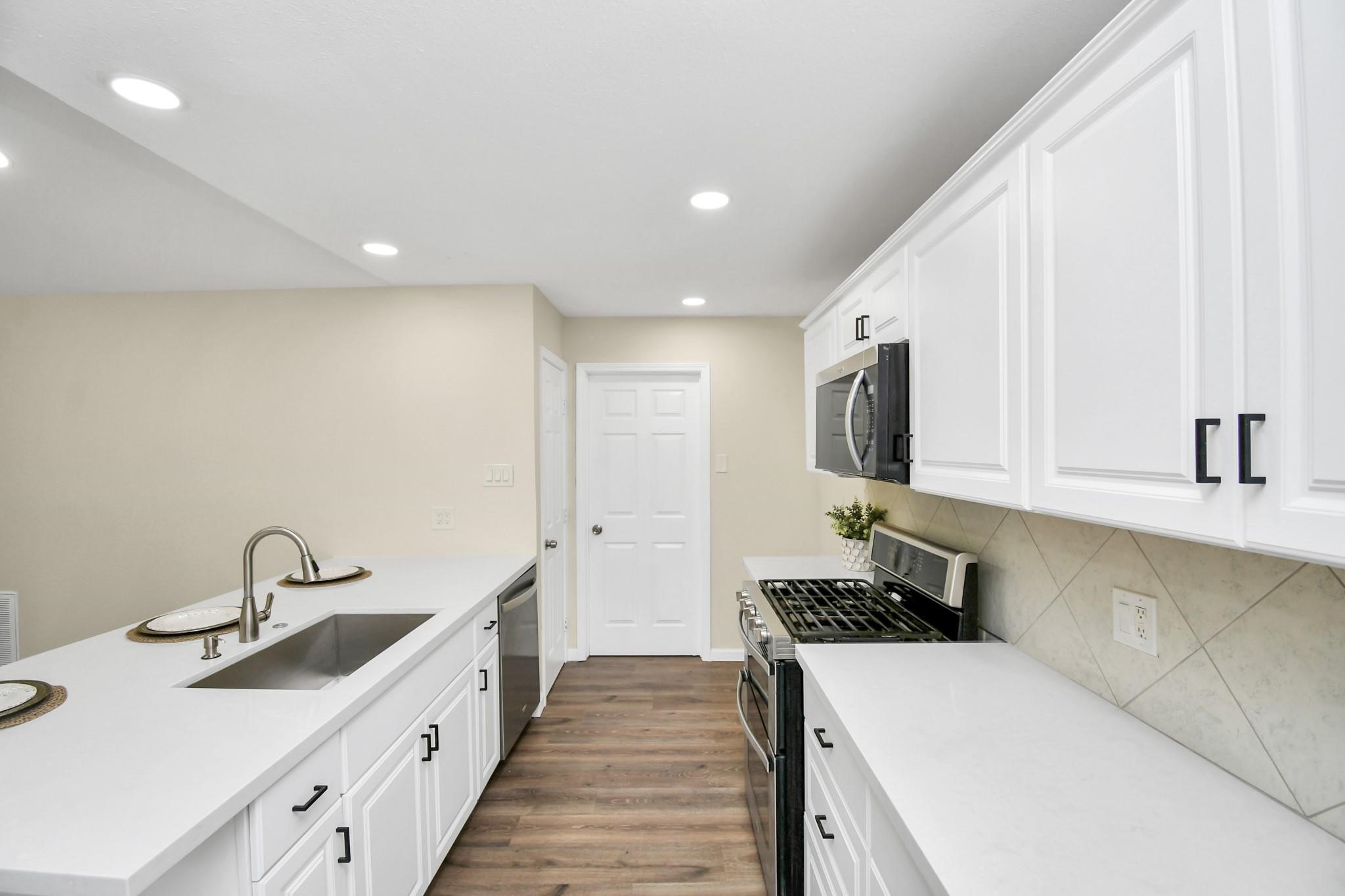 531 Edgebrook Drive Houston, TX 77034 - Photo 3 of 26 a kitchen with sink a stove and cabinets