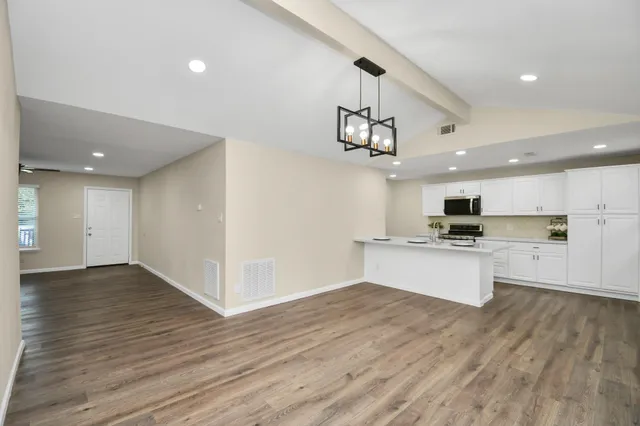 a view of kitchen with stainless steel appliances refrigerator stove microwave and cabinets