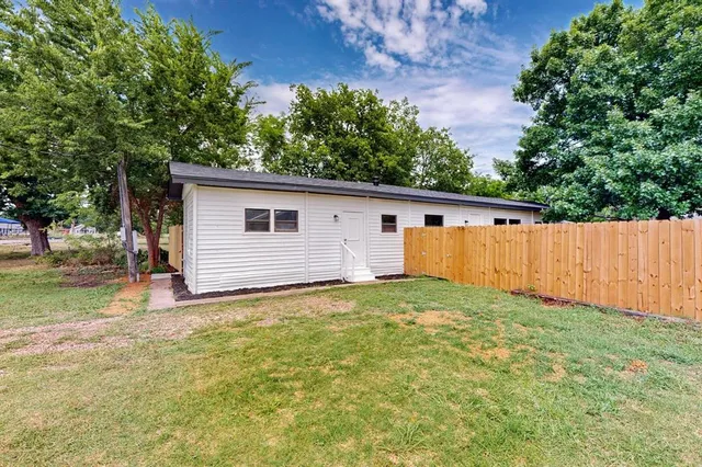 a view of a backyard with a house and large trees