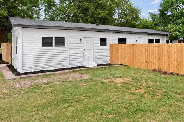 a view of a house with backyard and sitting area