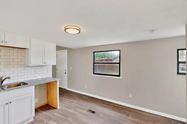 a kitchen with granite countertop a stove a sink and a refrigerator