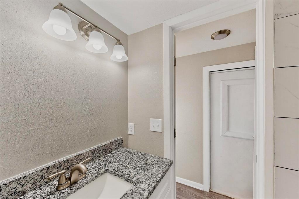 3112 Red River Street Melissa, TX 75454 - Photo 21 of 40 Bathroom with vanity, light wood-style floors, and a textured wall