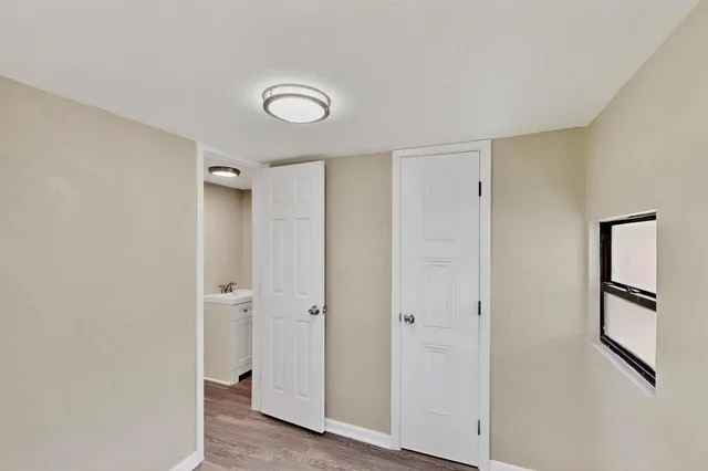 a view of an empty room with window and wooden floor