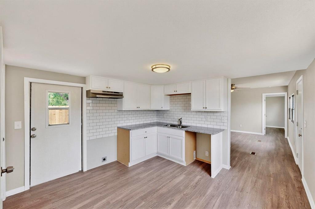 3112 Red River Street Melissa, TX 75454 - Photo 3 of 40 Kitchen featuring white cabinetry, light wood finished floors, backsplash, ceiling fan, and light stone counters