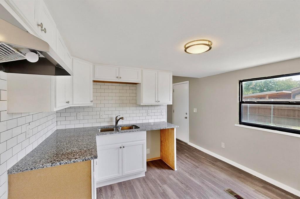 3112 Red River Street Melissa, TX 75454 - Photo 4 of 40 Kitchen featuring light stone countertops, tasteful backsplash, white cabinets, and light wood-type flooring