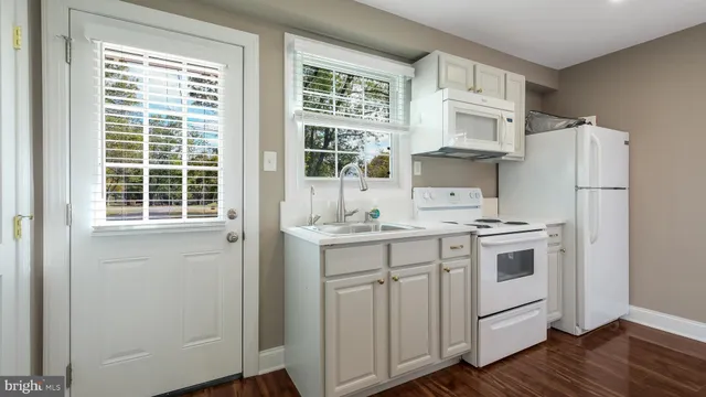 a kitchen with stainless steel appliances a sink cabinets and a window