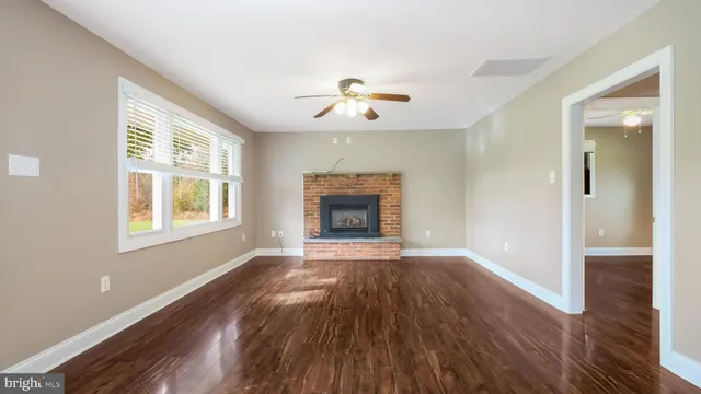 an empty room with windows and a fireplace