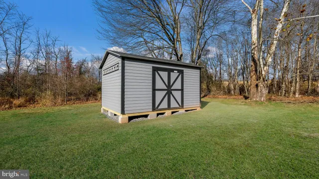 a view of backyard with wooden fence and a bench