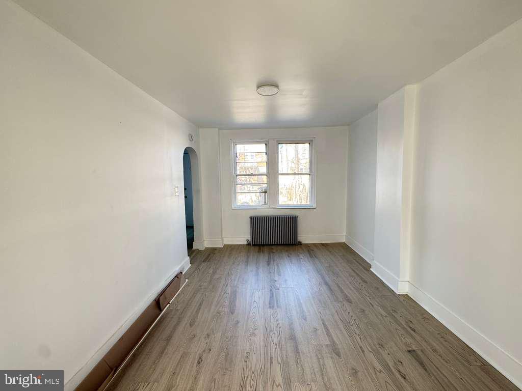 2892 North Constitution Road Camden, NJ 08104 - Photo 4 of 17 an empty room with wooden floor and windows