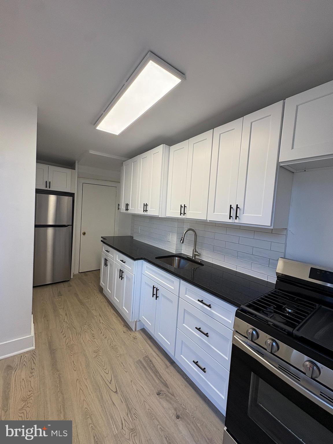 2892 North Constitution Road Camden, NJ 08104 - Photo 6 of 17 a kitchen with granite countertop a stove and a refrigerator