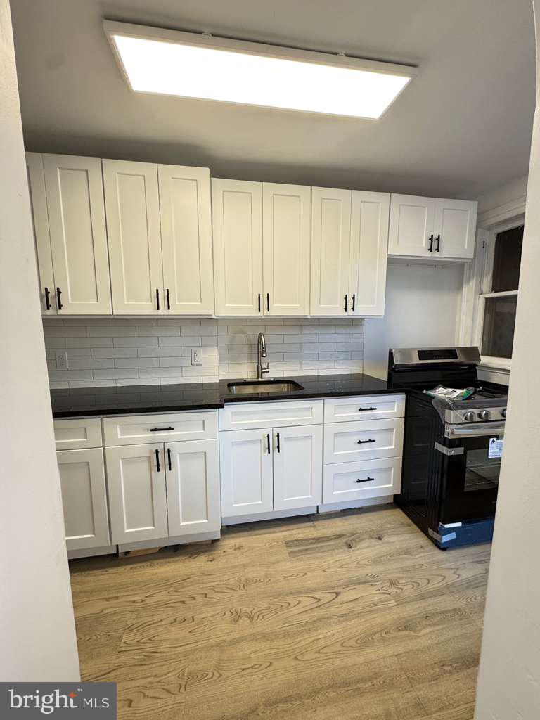 2892 North Constitution Road Camden, NJ 08104 - Photo 7 of 17 a kitchen with granite countertop a stove a sink and white cabinets