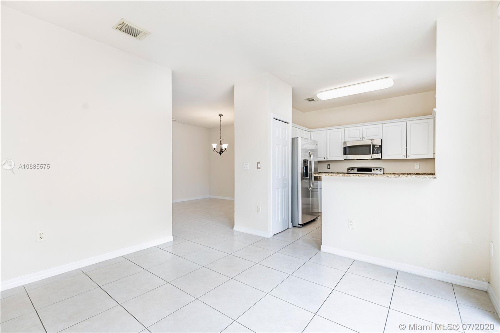 11926 Southwest 152nd Place Miami, FL 33196 - Photo 13 of 48 a kitchen with white cabinets and refrigerator